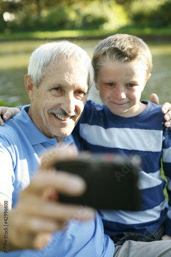 Photo: Senior man taking picture with his grandson Senior man taking picture with his grandson