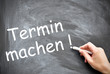Termin machen wird auf eine Tafel geschrieben
