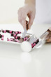 Doctor counting pills on pharmaceutical tray
