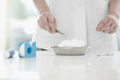 Doctor picking up cotton swab with forceps