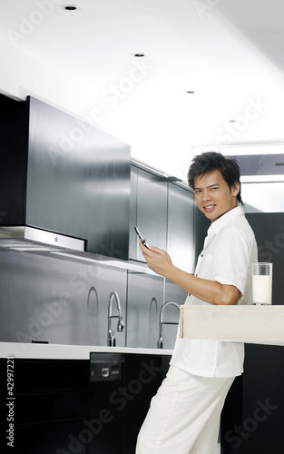 Photo: Man making a phone call in the kitchen Man making a phone call in the kitchen