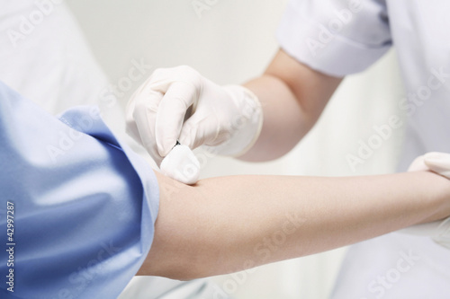 Photo: Doctor cleaning patient's arm before an injection Doctor cleaning patient's arm before an injection