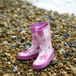 Pink children boots on the beach