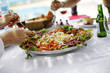 People sharing a large plate of dish