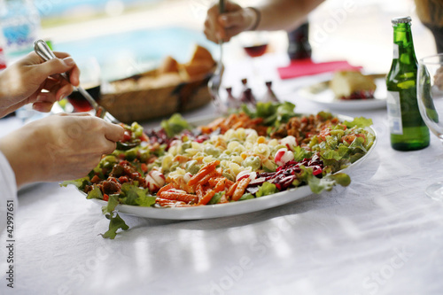Photo: People sharing a large plate of dish People sharing a large plate of dish
