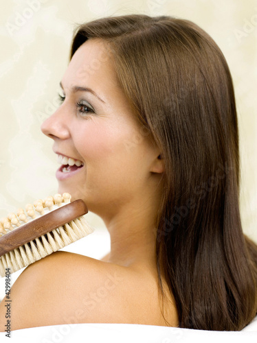 Photo: Woman holding a back scrub and massage brush Woman holding a back scrub and massage brush