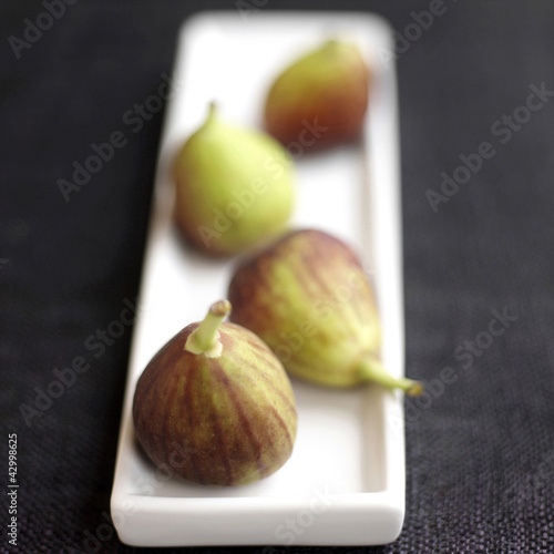 Photo: Close up of four figs on a small plate Close up of four figs on a small plate