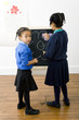 Photo : Girls colouring a drawing on chalkboard Girls colouring a drawing on chalkboard