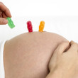 Pregnant woman arranging gummi bears on her stomach