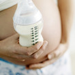 Pregnant woman with a baby bottle