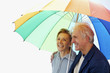 A couple chatting happily under a colorful umbrella