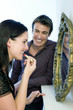 Man watching woman putting on lipstick