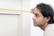 Man measuring mantelpiece with a tape measure