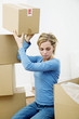 Woman stacking up sealed boxes