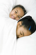 Girls sleeping together on the bed