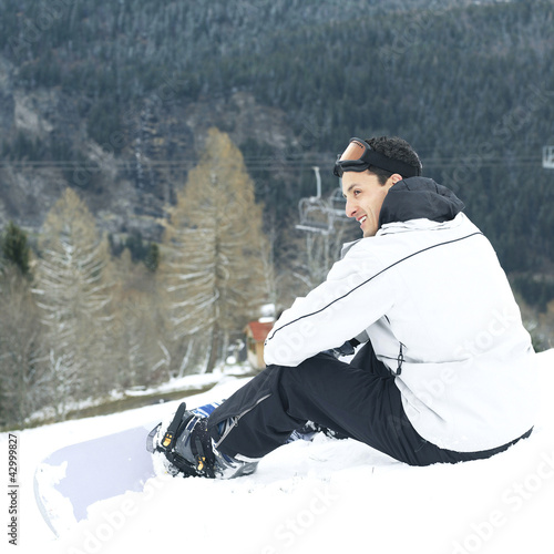 Photo: Male snowboarder smiling while looking away Male snowboarder smiling while looking away