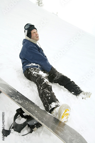 Photo: Male snowboarder with injured leg Male snowboarder with injured leg