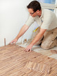 Foto: Carpenter at work is fitting wood parquet on the floor Carpenter at work is fitting wood parquet on the floor