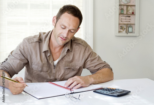 Photo: Man working at his desk in a home office Man working at his desk in a home office