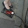 Businesswoman stepping on air pump