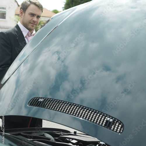 Photo: Businessman with an opened car hood Businessman with an opened car hood