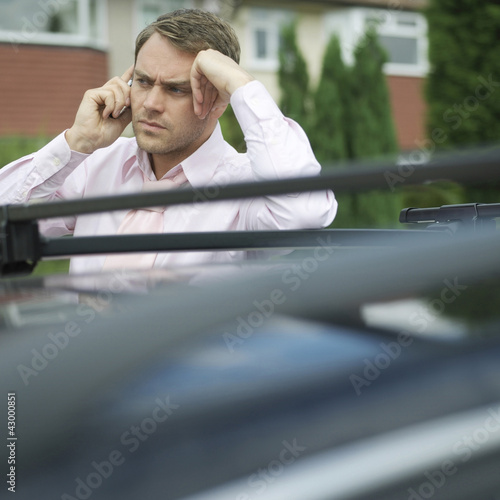 Photo: Businessman frowning while talking on the phone Businessman frowning while talking on the phone