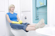 Woman resting her legs on the bathtub while holding a cleaning brush
