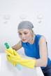 Woman with rubber gloves reading instructions on cleaning detergent