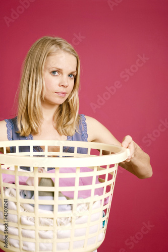 Photo: Woman holding a basket full of laundry Woman holding a basket full of laundry