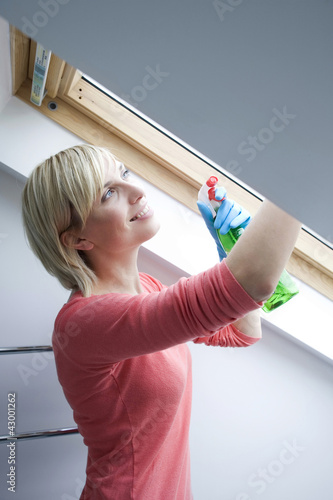 Photo: Woman wiping the attic window Woman wiping the attic window