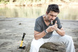 rough man standing by the river lighting up a cigarette - series