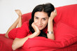 Frau liegt auf rotem Sofa