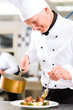 Foto: Koch in Restaurant oder Hotel Küche beim kochen Koch in Restaurant oder Hotel Küche beim kochen