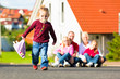 Familie sitzt vor ihrem Haus