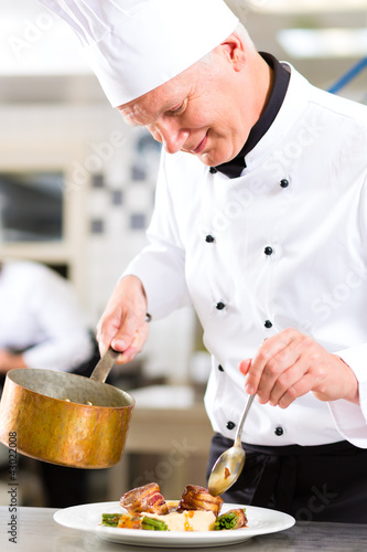 Foto: Koch in Restaurant oder Hotel Küche beim kochen Koch in Restaurant oder Hotel Küche beim kochen