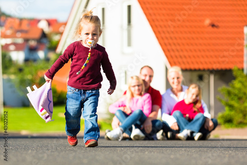 Photo: Familie sitzt vor ihrem Haus Familie sitzt vor ihrem Haus
