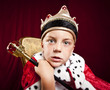Foto: little boy dressed ad a king on red velvet background little boy dressed ad a king on red velvet background