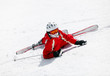 Photo: Female skier looking at camera after falling down on slope Female skier looking at camera after falling down on slope