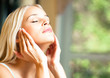 Happy smiling woman applying creme, indoor