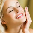 Foto: Happy smiling woman applying creme, indoor Happy smiling woman applying creme, indoor