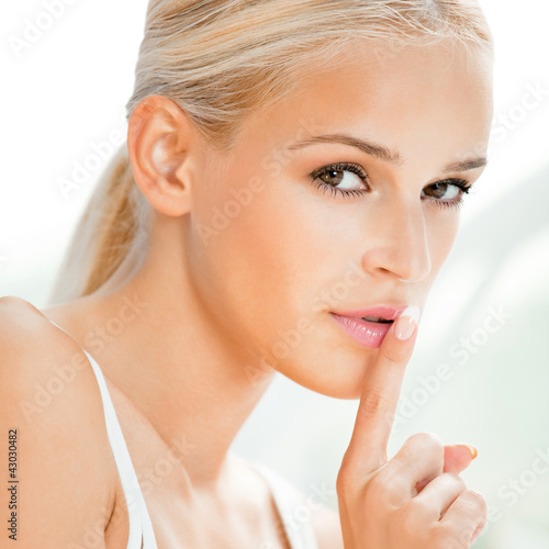 Foto: Beautiful blond woman with finger on lips Beautiful blond woman with finger on lips