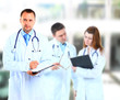 Portrait doctor smiling with colleagues in background