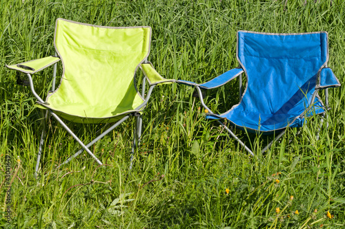 Foto: Two empty folding chair on the green grass Two empty folding chair on the green grass