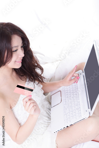 Photo: Woman shopping with computer and credit card Woman shopping with computer and credit card