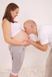 Husband kisses the stomach of pregnant wife