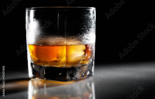 Photo: Closeup misted glass of whiskey in backlight Closeup misted glass of whiskey in backlight