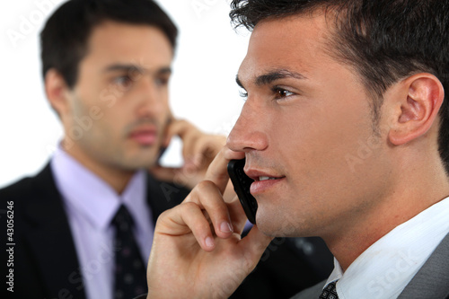 Photo: businessmen talking on their cell businessmen talking on their cell