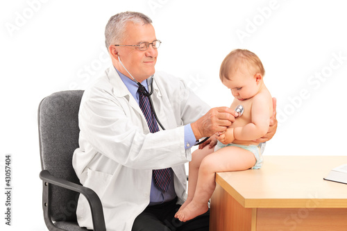 Photo: A male doctor examining a baby boy in his office A male doctor examining a baby boy in his office