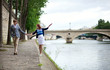 Couple is walking by the Seine embankment in Paris, girl is bala