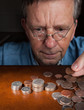 Senior man counting cash into piles